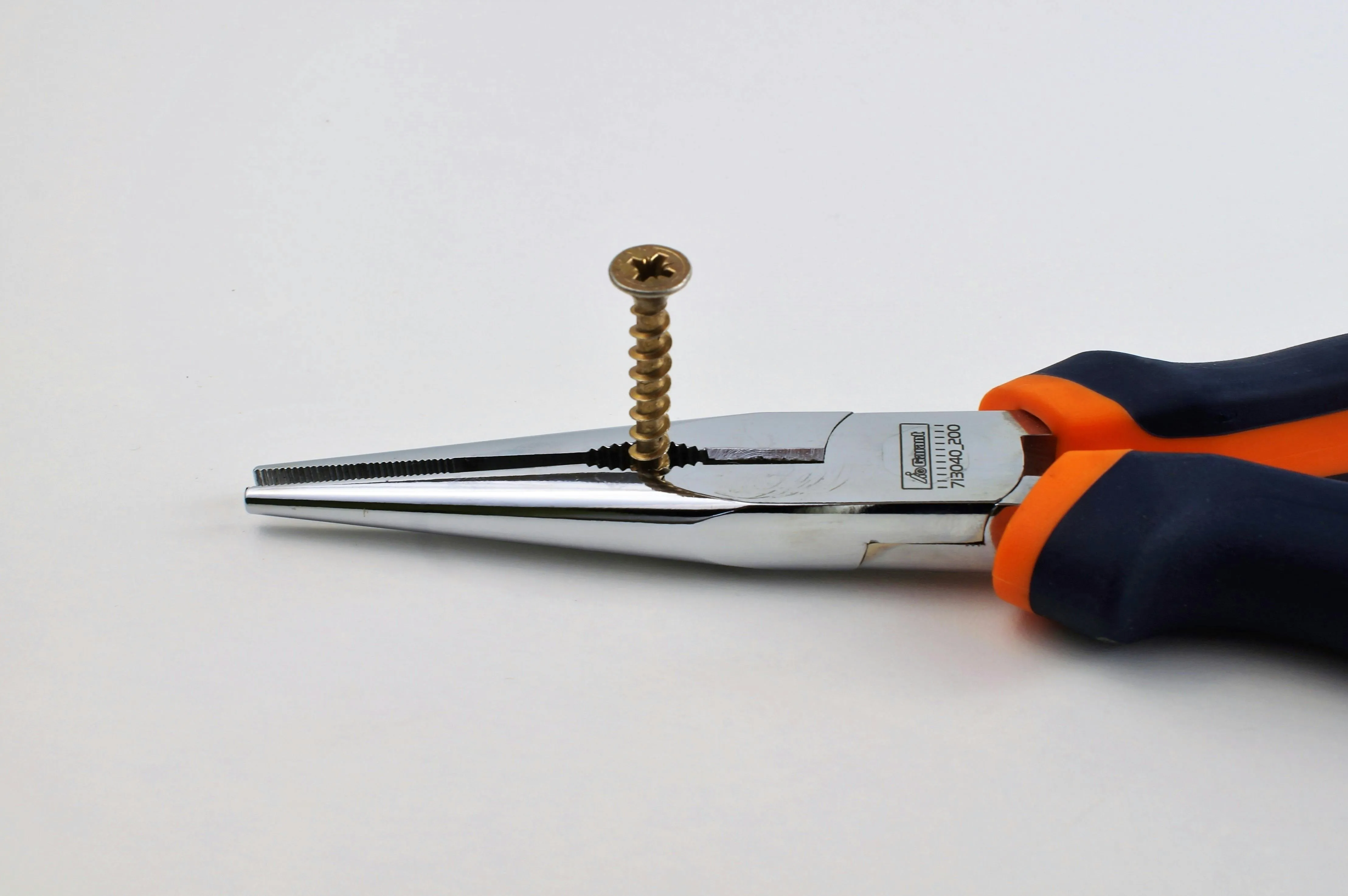 Pinza che trattiene una vite in ottone